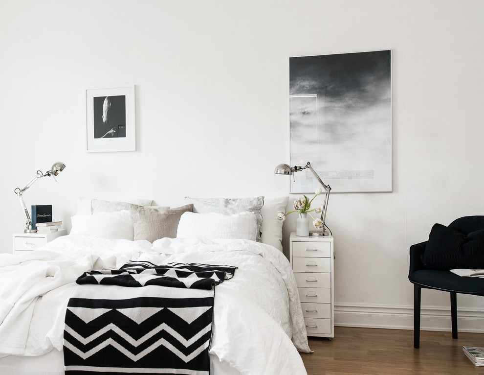 Mittelgroßes Skandinavisches Hauptschlafzimmer ohne Kamin mit weißer Wandfarbe und braunem Holzboden in Göteborg