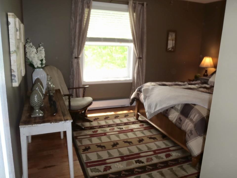 Ejemplo de dormitorio principal rústico extra grande sin chimenea con paredes rosas y suelo de madera clara