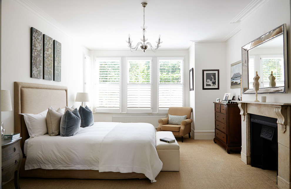 ロンドンにあるトランジショナルスタイルのおしゃれな主寝室 (白い壁、カーペット敷き、標準型暖炉、石材の暖炉まわり)