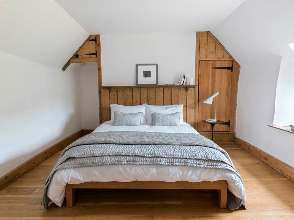Imagen de dormitorio blanco y madera de estilo de casa de campo con paredes blancas y techo inclinado