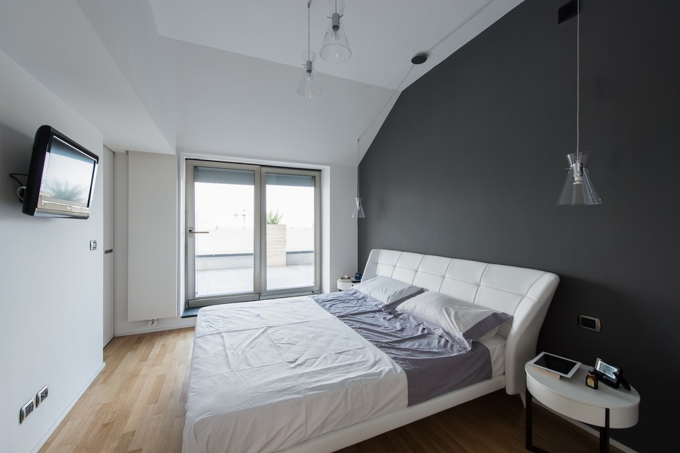 Diseño de dormitorio principal contemporáneo grande sin chimenea con paredes negras y suelo de madera clara