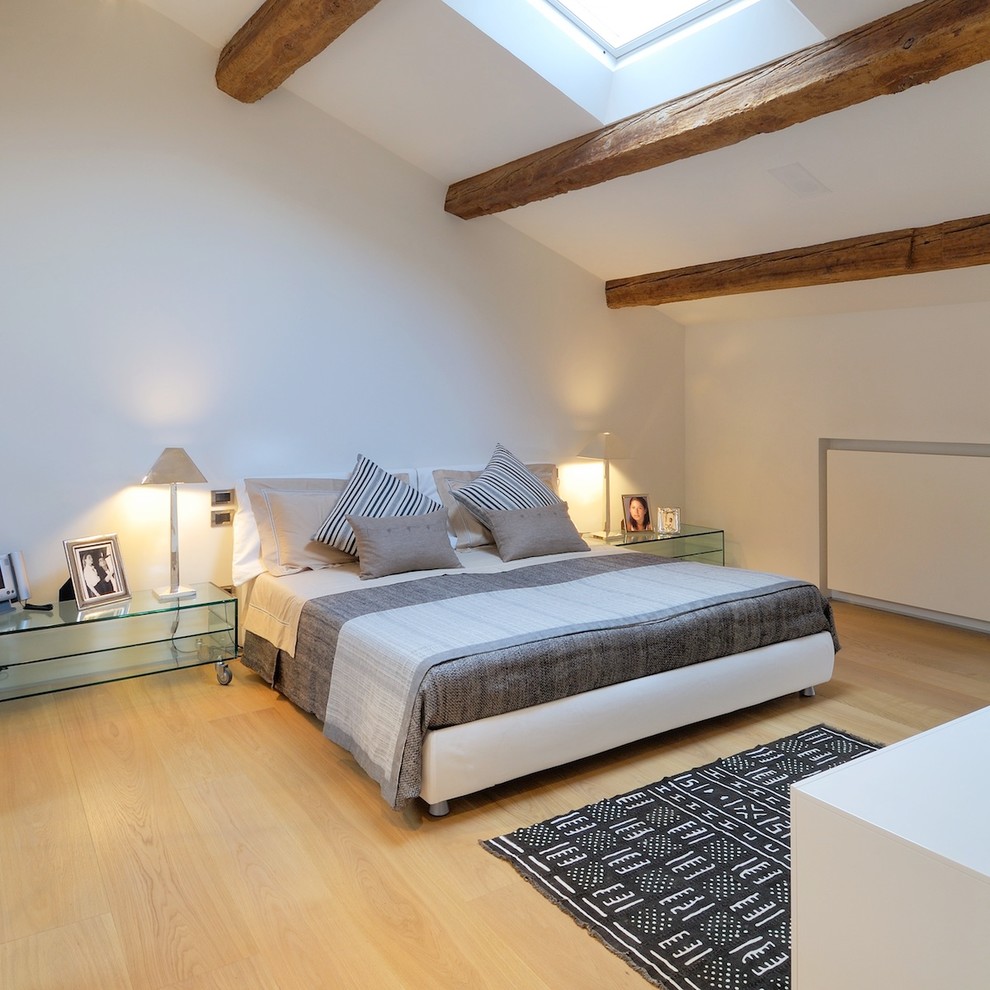 Photo of a contemporary master bedroom in Other with white walls and light hardwood flooring.