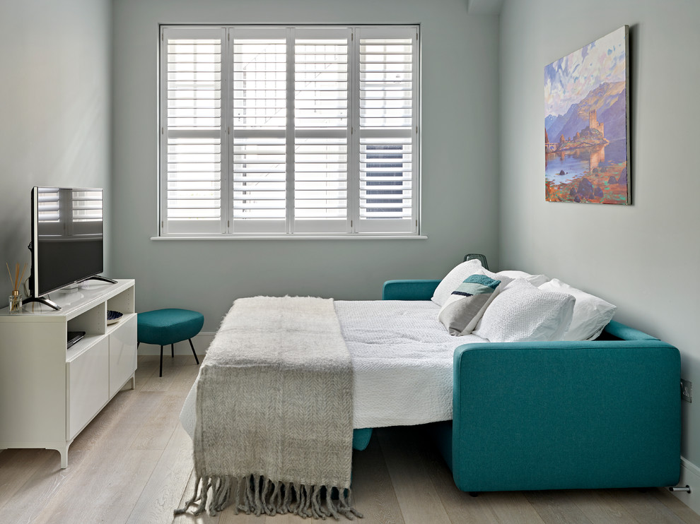 Kleines Modernes Schlafzimmer ohne Kamin mit grauer Wandfarbe und hellem Holzboden in London