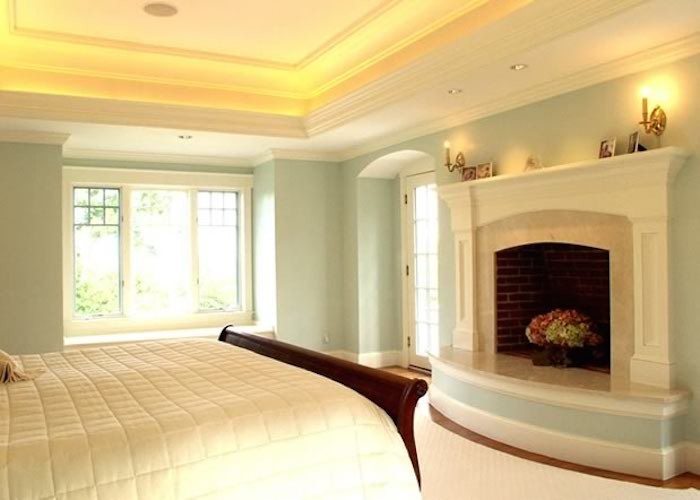 Inspiration pour une chambre avec moquette marine avec un mur vert, une cheminée standard et un manteau de cheminée en plâtre.