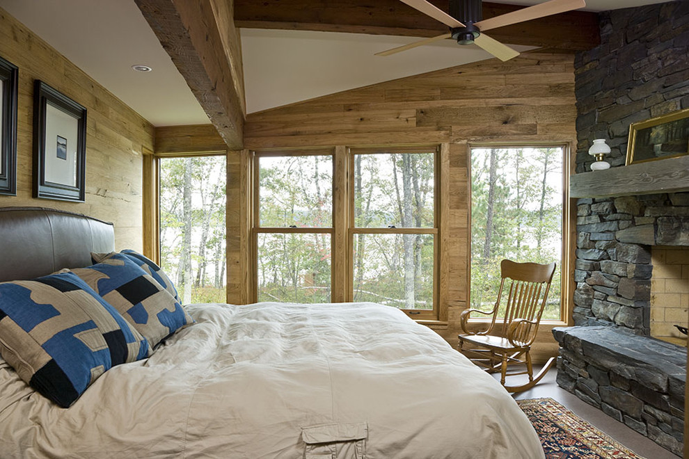 Cette photo montre une chambre montagne avec un manteau de cheminée en pierre et une cheminée standard.