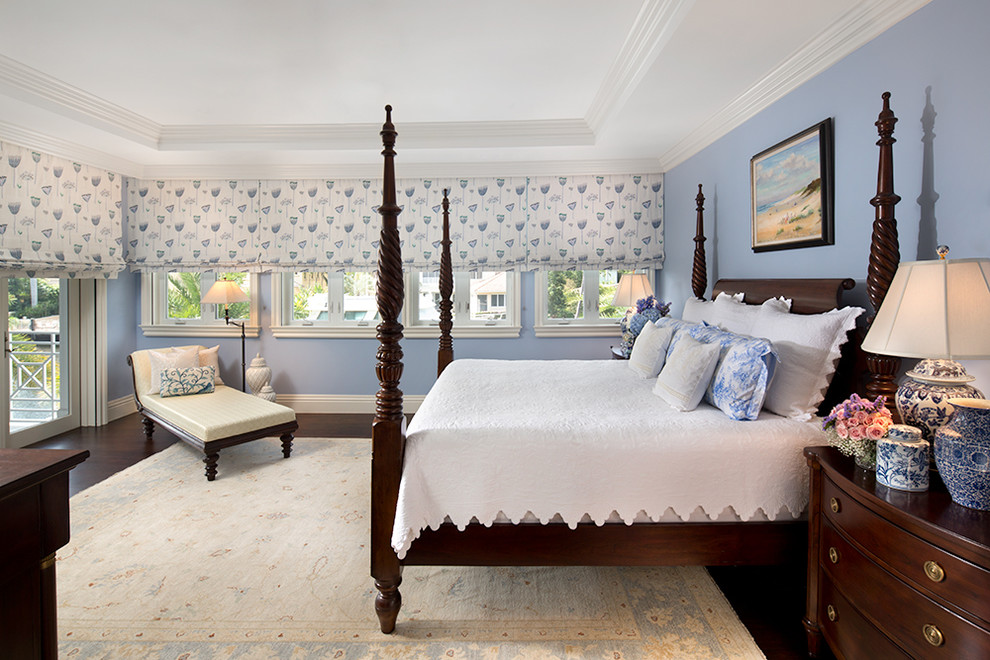 Modelo de dormitorio principal tradicional grande con suelo de madera oscura, paredes azules y suelo gris