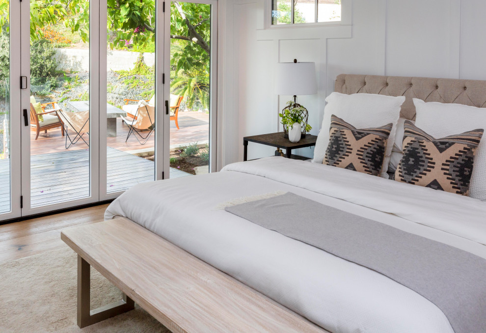 Ejemplo de dormitorio principal minimalista grande con paredes blancas, suelo de madera clara y boiserie