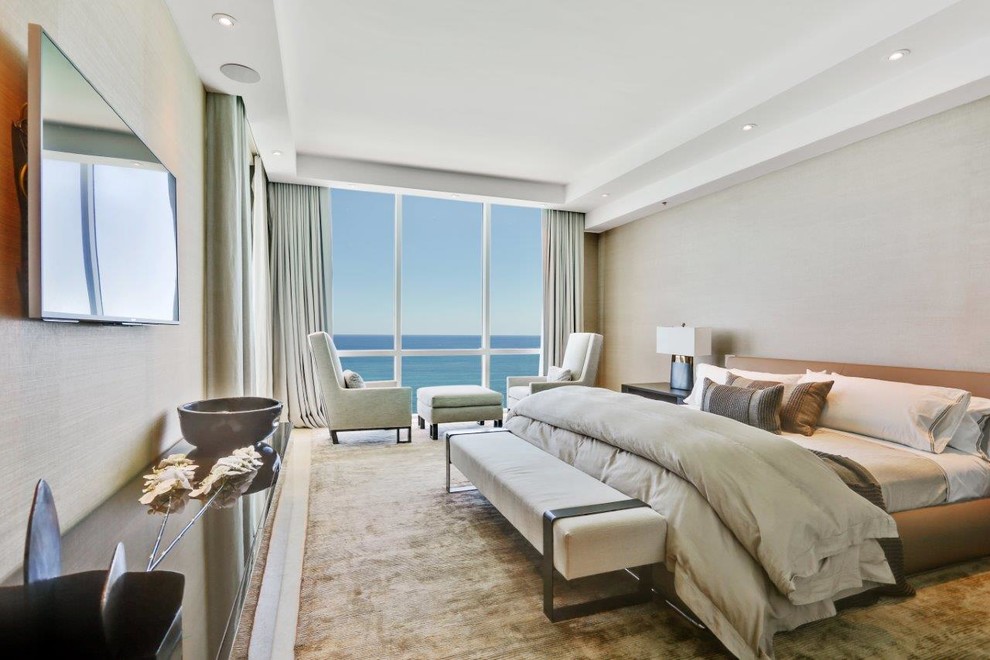 Inspiration for a large contemporary master limestone floor bedroom remodel in Miami with beige walls