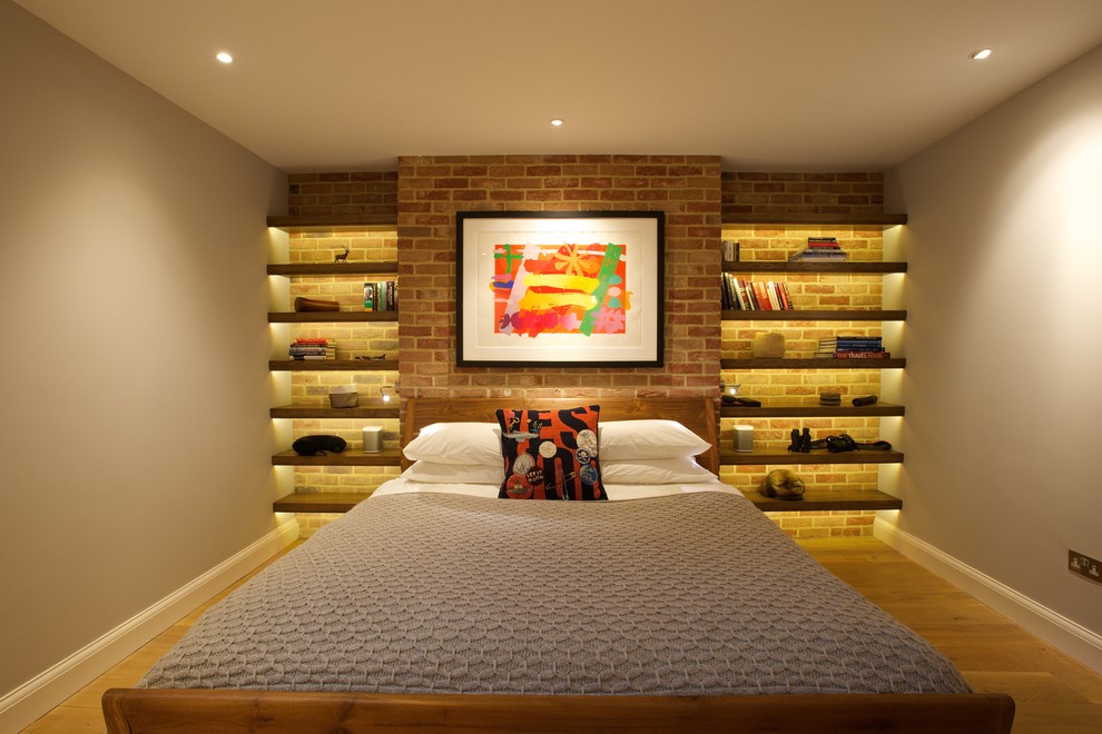 Mid-sized trendy medium tone wood floor and brown floor bedroom photo in London with gray walls