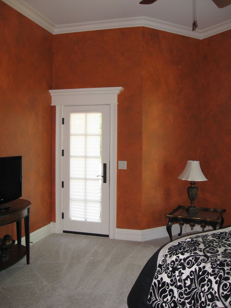 Inredning av ett klassiskt stort gästrum, med orange väggar och heltäckningsmatta