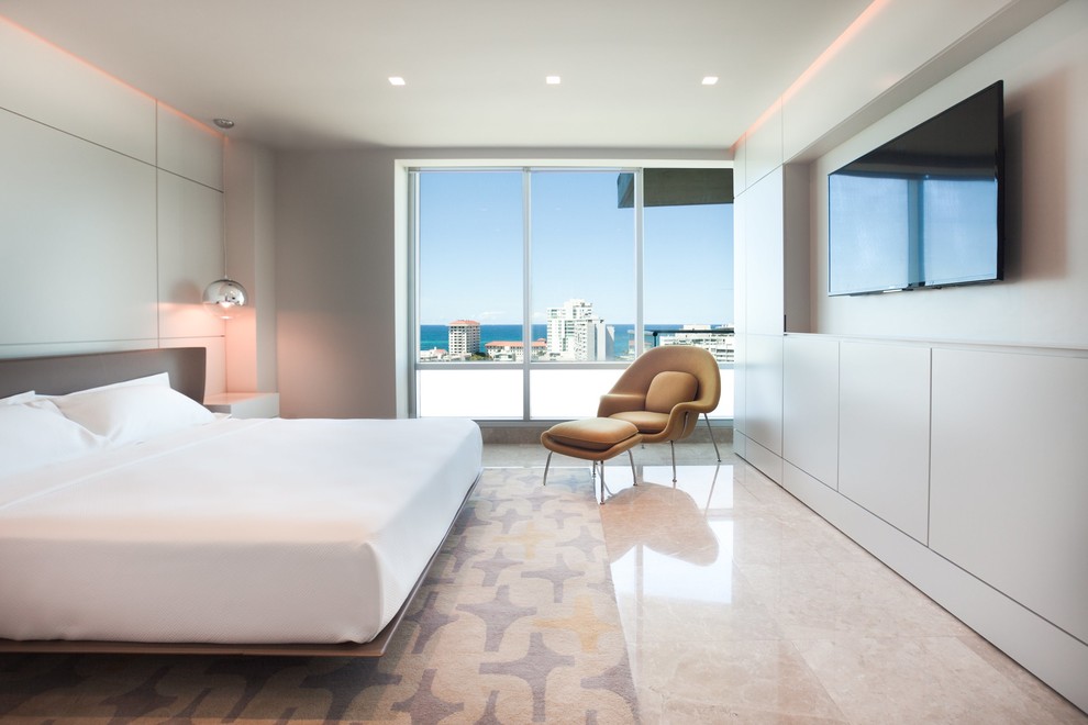 Ejemplo de dormitorio principal minimalista grande sin chimenea con paredes beige, suelo de mármol y suelo beige
