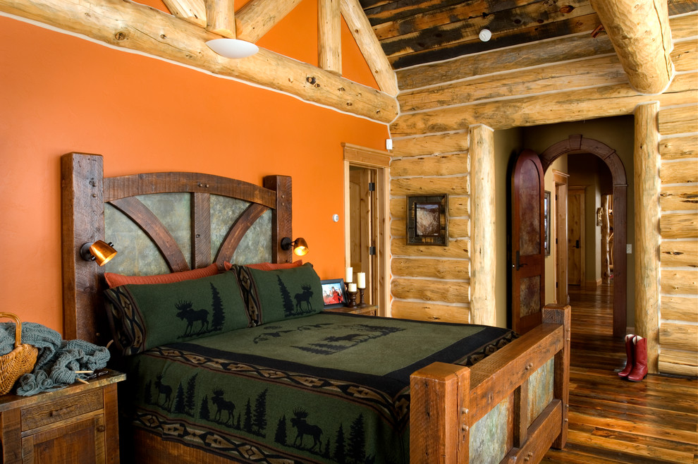 Réalisation d'une chambre chalet avec un mur orange et un sol en bois brun.