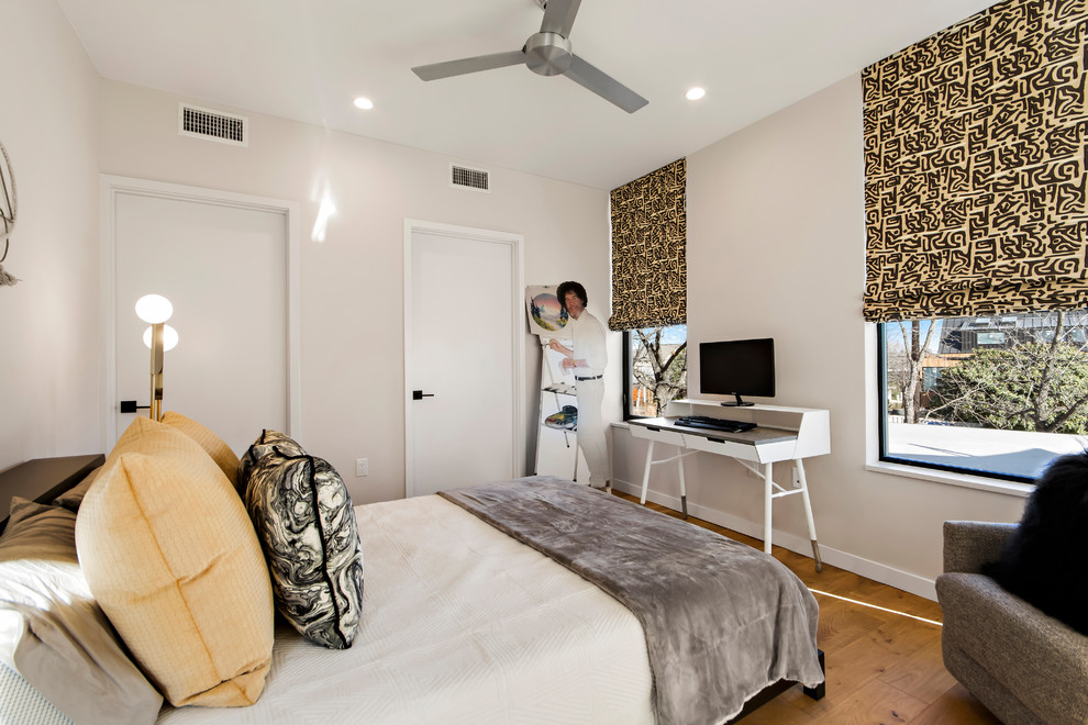 Foto de habitación de invitados actual de tamaño medio sin chimenea con paredes blancas, suelo de madera clara y suelo beige