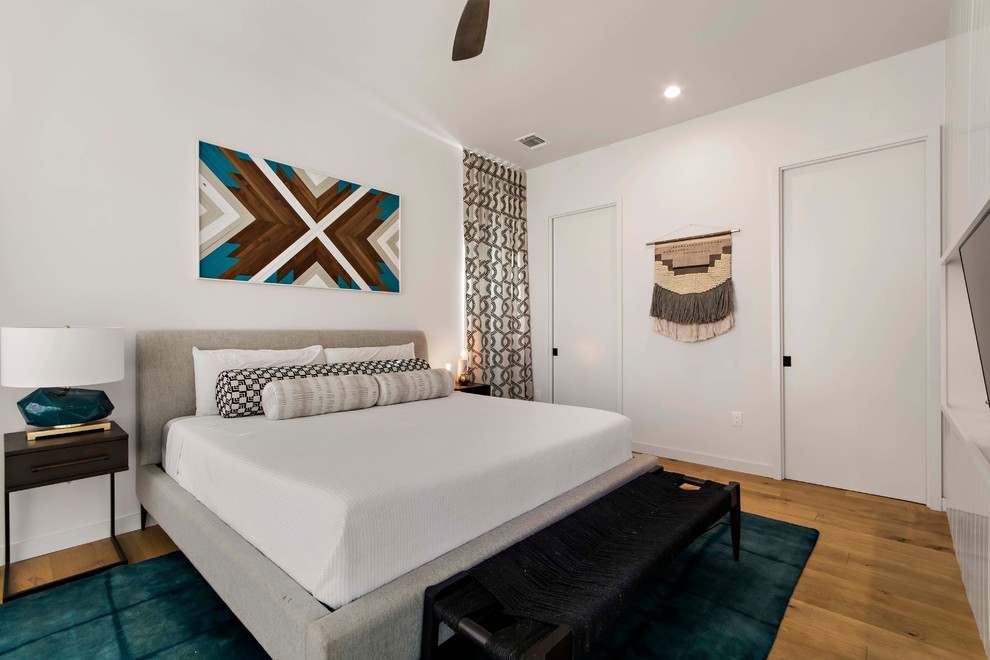 Diseño de dormitorio principal contemporáneo de tamaño medio sin chimenea con paredes blancas, suelo de madera clara y suelo beige