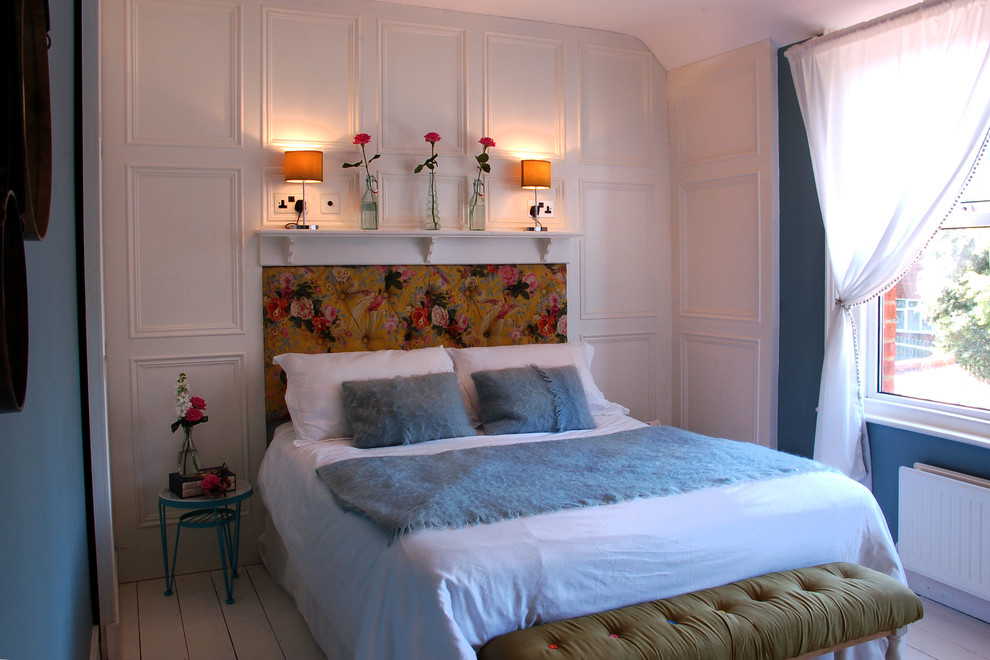 Ispirazione per una camera degli ospiti boho chic di medie dimensioni con pareti blu, pavimento in legno verniciato e nessun camino