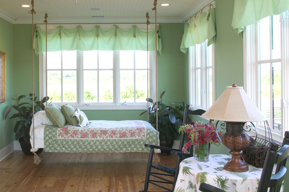 Imagen de dormitorio campestre de tamaño medio con paredes verdes y suelo de madera clara