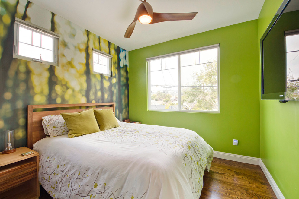 Bild på ett funkis sovrum, med gröna väggar och mellanmörkt trägolv