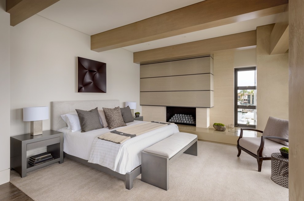 На фото: гостевая спальня (комната для гостей) в современном стиле с белыми стенами и горизонтальным камином с