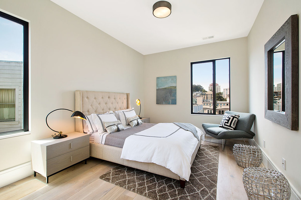 Ejemplo de dormitorio actual con paredes beige y suelo de madera en tonos medios
