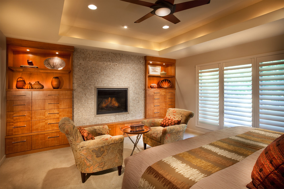 Modernes Schlafzimmer mit beiger Wandfarbe, Teppichboden und Kaminumrandung aus Stein in Omaha