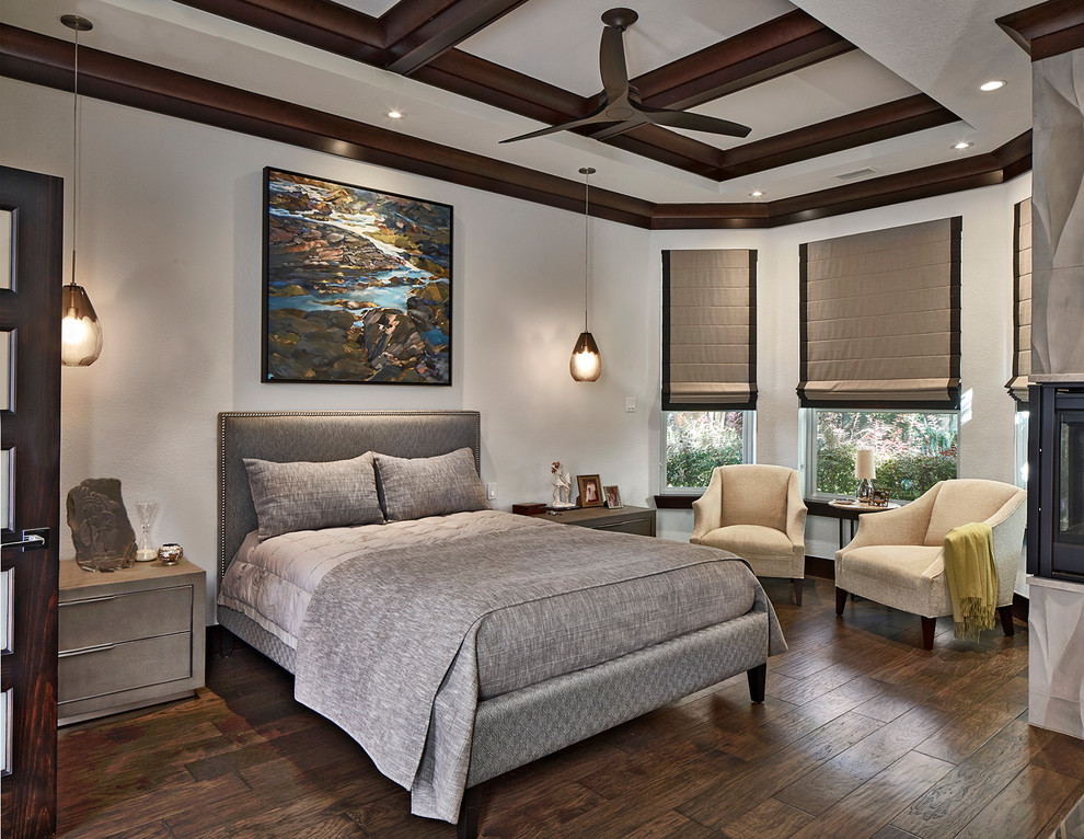 Photo of a classic grey and brown bedroom in Dallas with white walls, dark hardwood flooring, a corner fireplace, a tiled fireplace surround and brown floors.