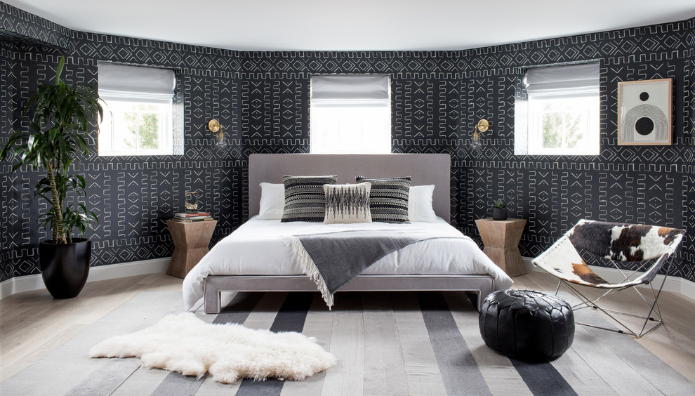 Trendy master light wood floor bedroom photo in New York with black walls