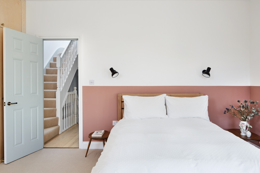 Aménagement d'une chambre rétro de taille moyenne avec un mur rose, une cheminée standard, un manteau de cheminée en plâtre et un sol beige.