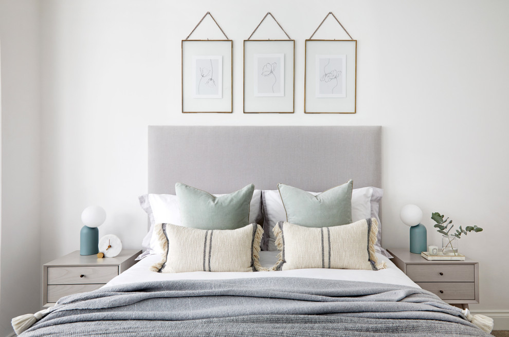 Immagine di una camera da letto scandinava con pareti bianche, pavimento in legno massello medio e pavimento marrone