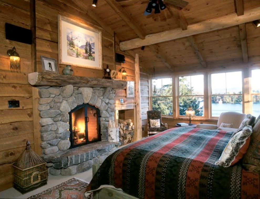 Inspiration for a mid-sized master carpeted bedroom remodel in Burlington with brown walls, a standard fireplace and a stone fireplace