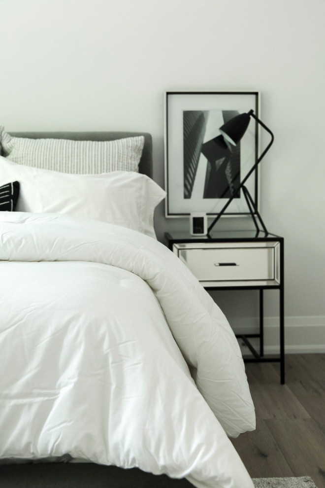 Foto de habitación de invitados minimalista pequeña sin chimenea con paredes blancas, suelo de madera en tonos medios y suelo gris