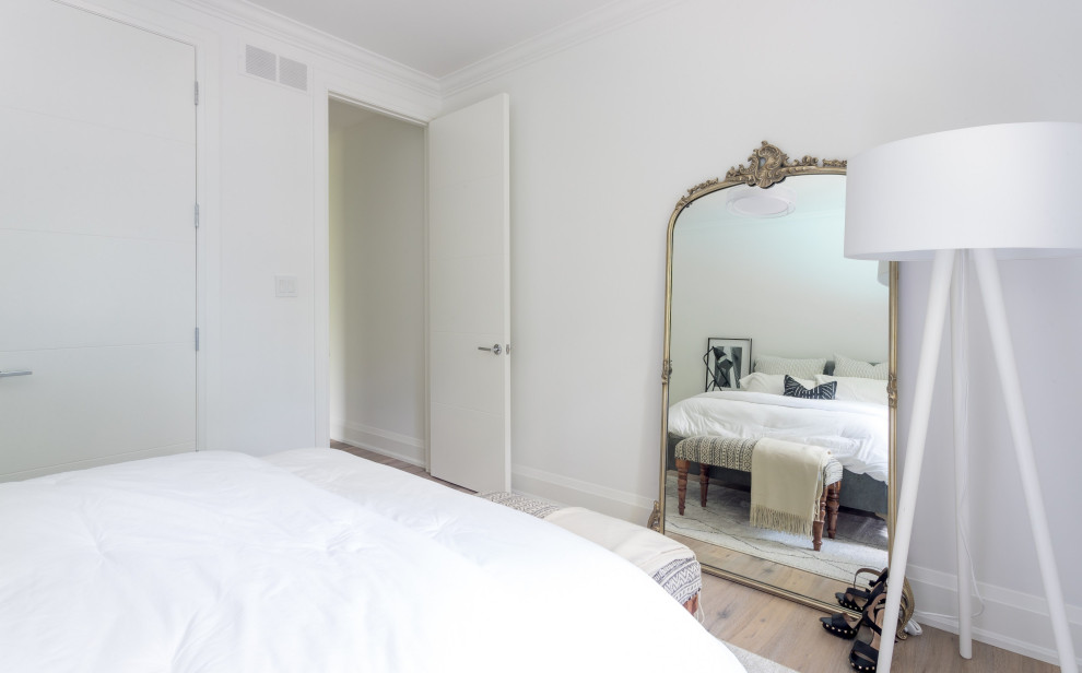 Cette image montre une petite chambre d'amis minimaliste avec un mur blanc, un sol en bois brun, aucune cheminée et un sol gris.