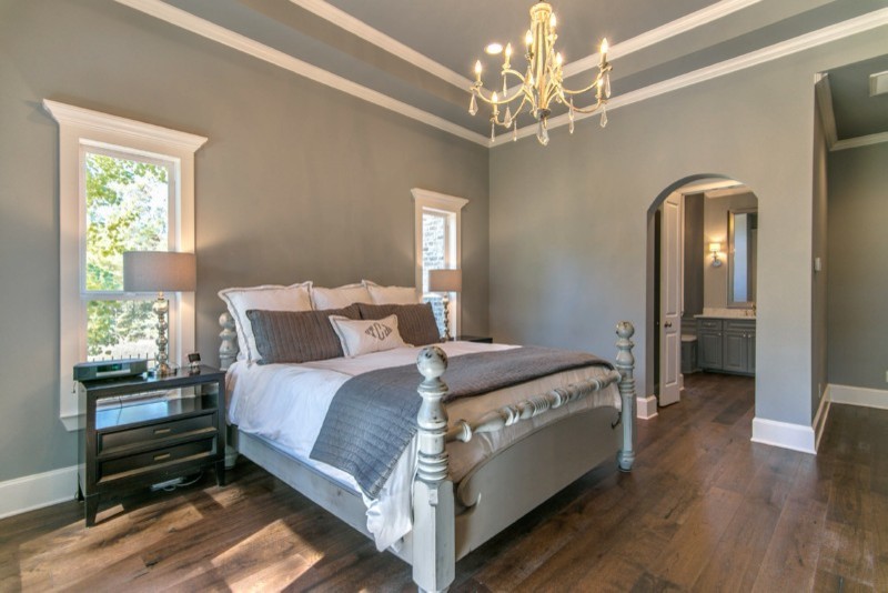 Ejemplo de dormitorio principal de estilo americano grande sin chimenea con paredes grises, suelo de madera oscura y suelo marrón