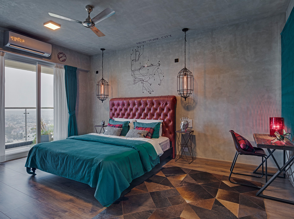 This is an example of an industrial grey and brown bedroom in Bengaluru with grey walls, dark hardwood flooring and brown floors.