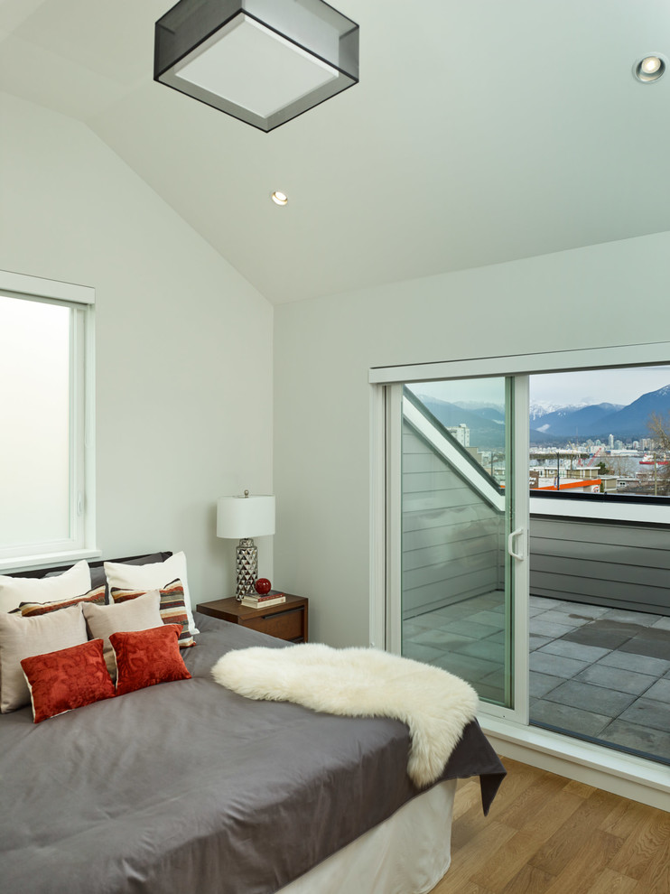 Mittelgroßes Modernes Hauptschlafzimmer ohne Kamin mit grauer Wandfarbe und hellem Holzboden in Vancouver
