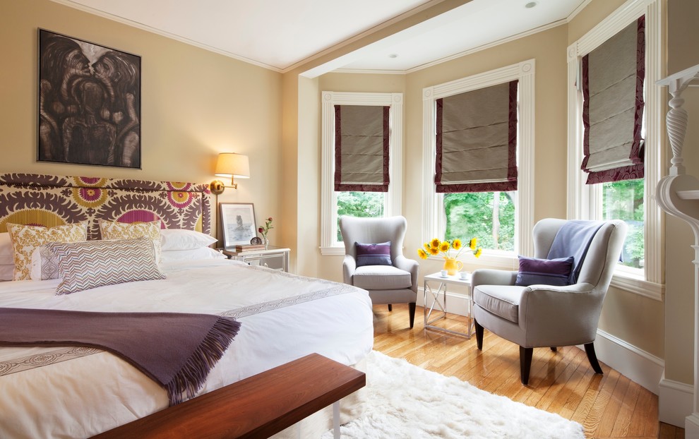 Foto di una camera da letto vittoriana con pareti beige e pavimento in legno massello medio