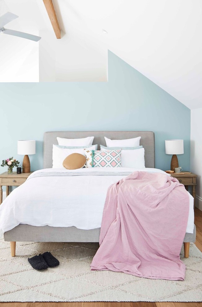 Idée de décoration pour une chambre parentale tradition avec un mur bleu et parquet clair.