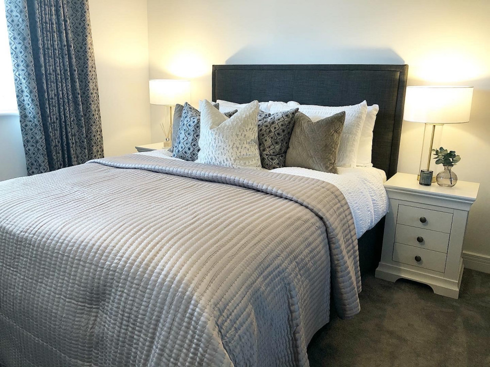 Example of a mid-sized farmhouse guest carpeted and gray floor bedroom design in Hampshire with white walls and no fireplace