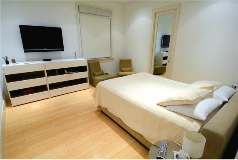 Mid-sized trendy guest bamboo floor bedroom photo in Miami with white walls and no fireplace