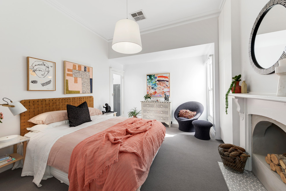 This is an example of a classic master and grey and pink bedroom in Melbourne with white walls, carpet, a standard fireplace, a stone fireplace surround and grey floors.