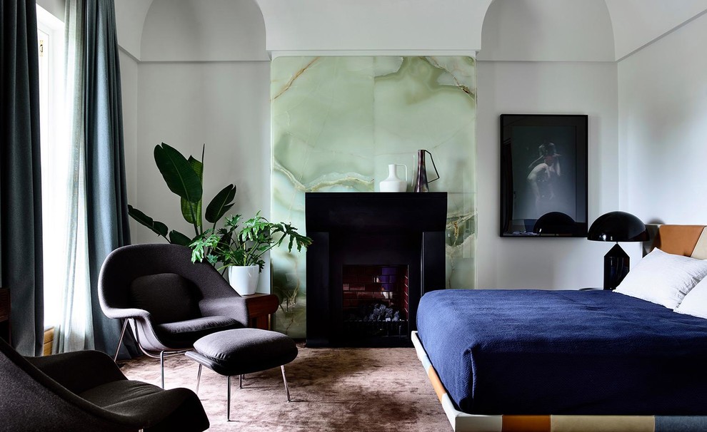 Foto de dormitorio moderno con paredes grises, moqueta, todas las chimeneas y suelo marrón