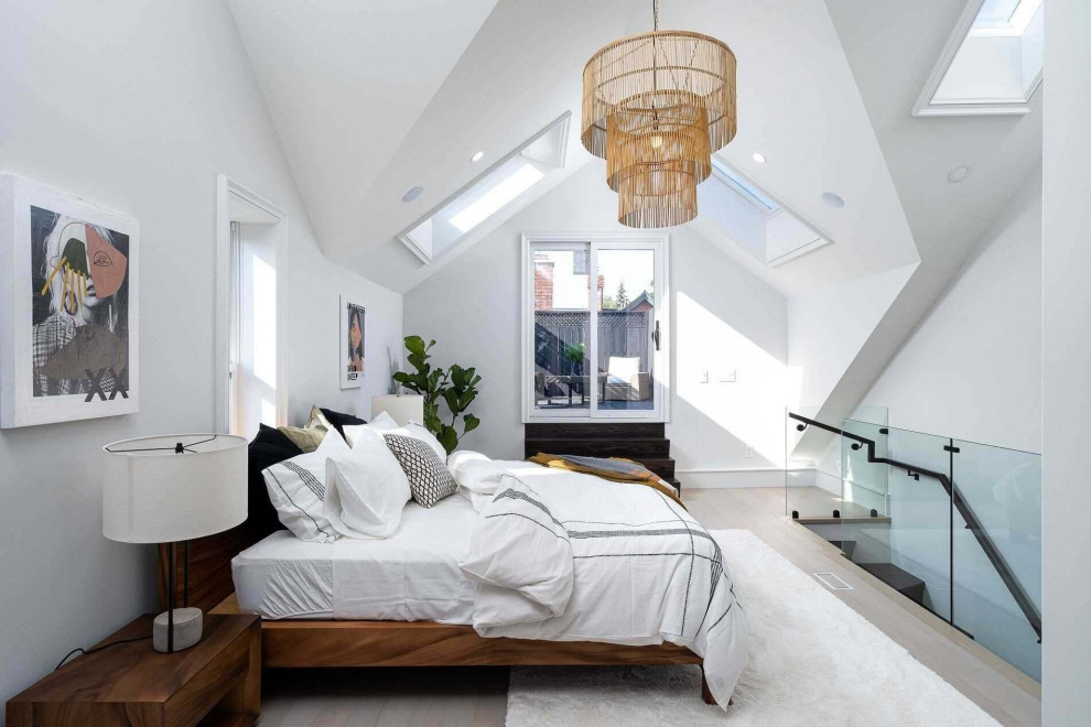 トロントにあるコンテンポラリースタイルのおしゃれなロフト寝室 (白い壁、淡色無垢フローリング、ベージュの床、三角天井) のインテリア