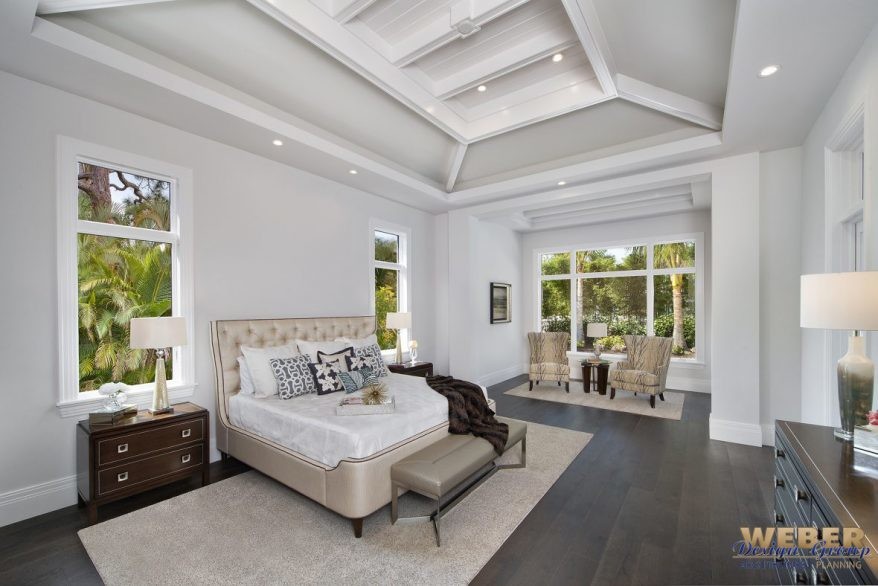 Large contemporary master bedroom in Miami with white walls, dark hardwood flooring and brown floors.
