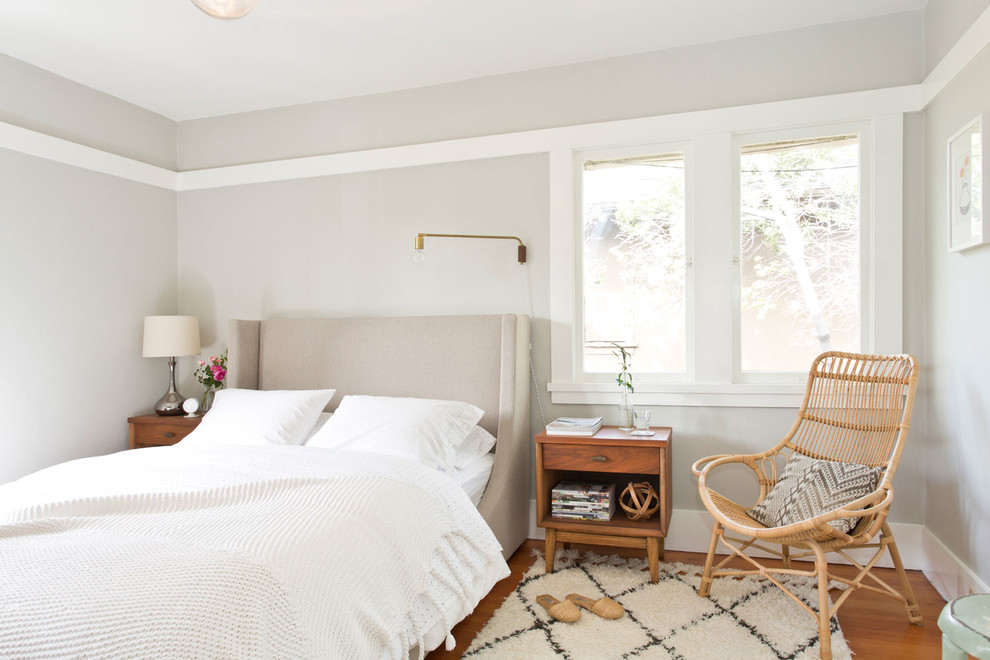 Diseño de dormitorio escandinavo con paredes grises y suelo de madera en tonos medios