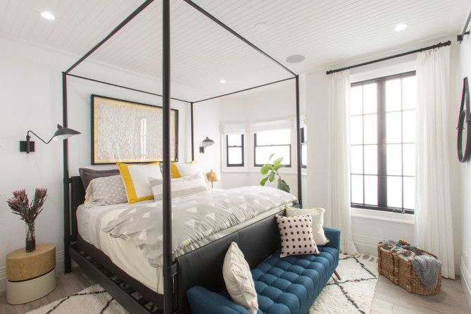 Modelo de habitación de invitados tradicional renovada de tamaño medio con paredes blancas, suelo de madera clara y suelo marrón