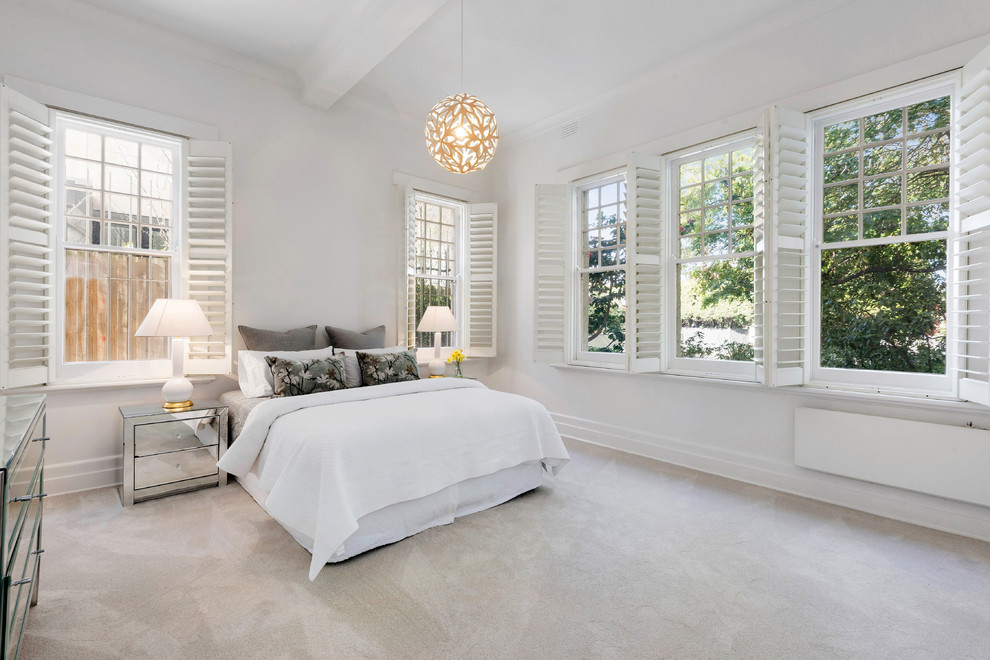Photo of a large traditional master bedroom in Melbourne with white walls, carpet, no fireplace and beige floors.