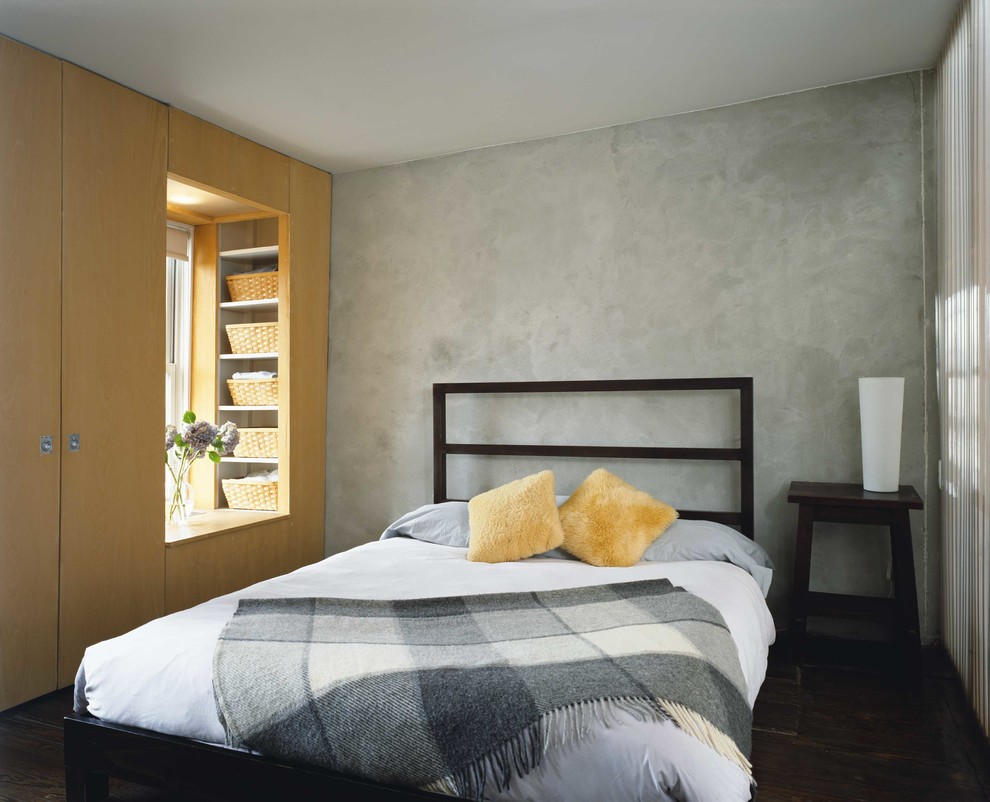 Medium sized contemporary master bedroom in New York with grey walls and dark hardwood flooring.