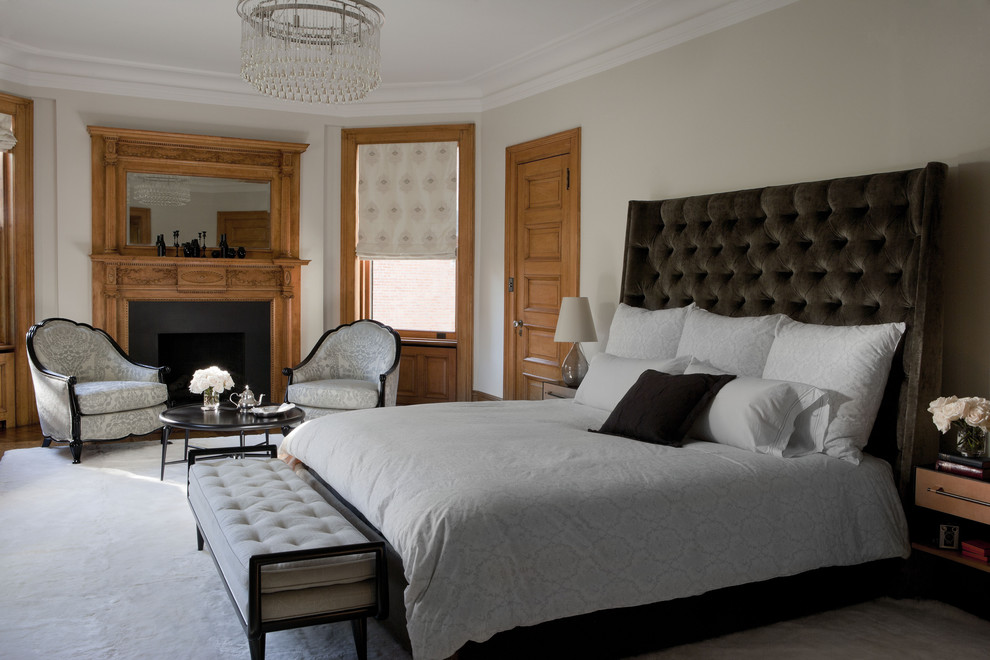 Cette photo montre une chambre chic avec un mur beige, une cheminée standard et un manteau de cheminée en bois.