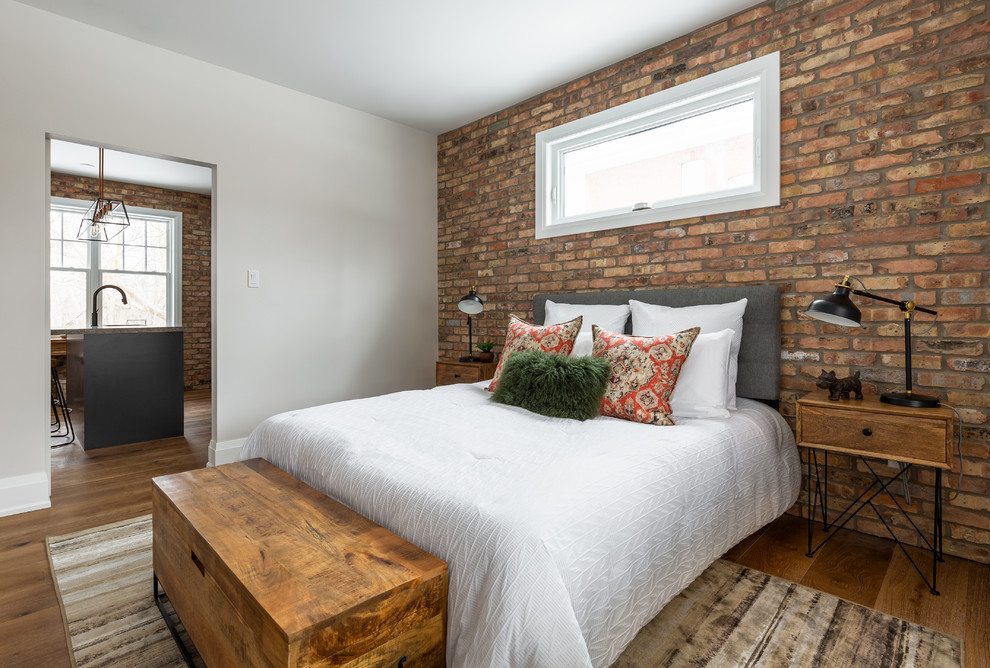 Example of an urban medium tone wood floor and brown floor bedroom design in Toronto with gray walls and no fireplace
