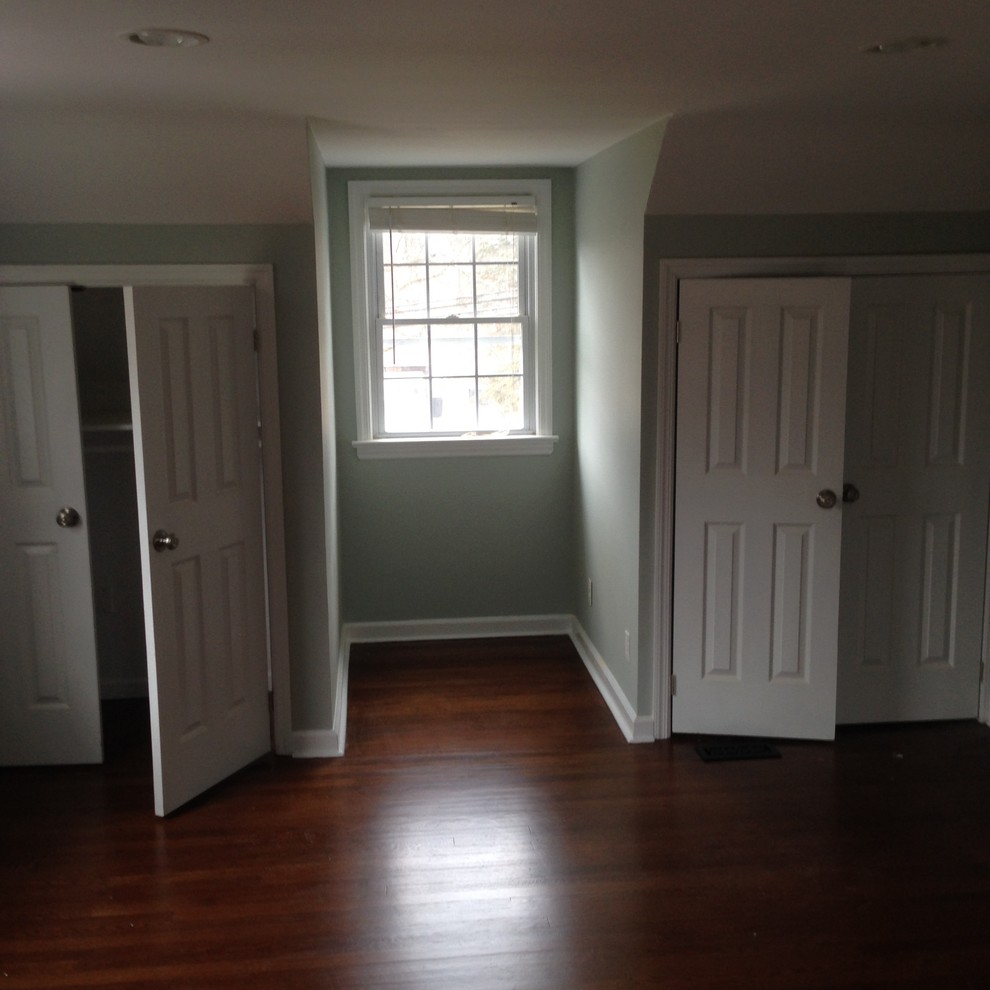 Cette photo montre une chambre tendance de taille moyenne avec un mur gris et parquet foncé.
