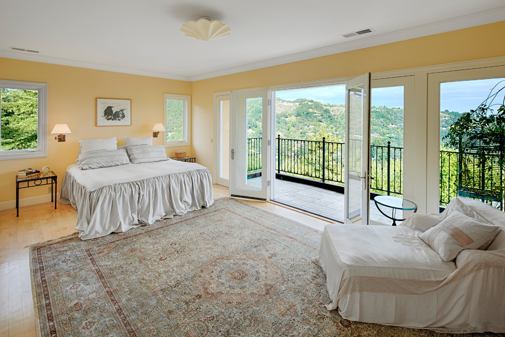 This is an example of a medium sized mediterranean master bedroom in San Francisco with yellow walls and light hardwood flooring.